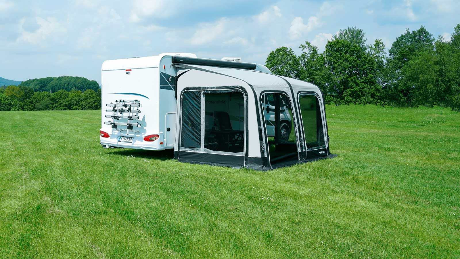 Wohnmobil mit Vorzelt auf grüner Wiese