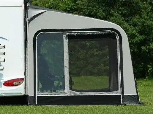 Vorzelteingang an Wohnmobil auf Wiese und Waldkulisse