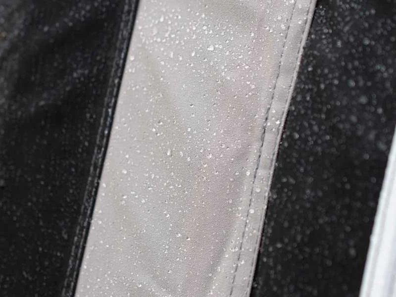 Stoff mit Wassertropfen, schwarz-weiß Muster, Nahaufnahme.