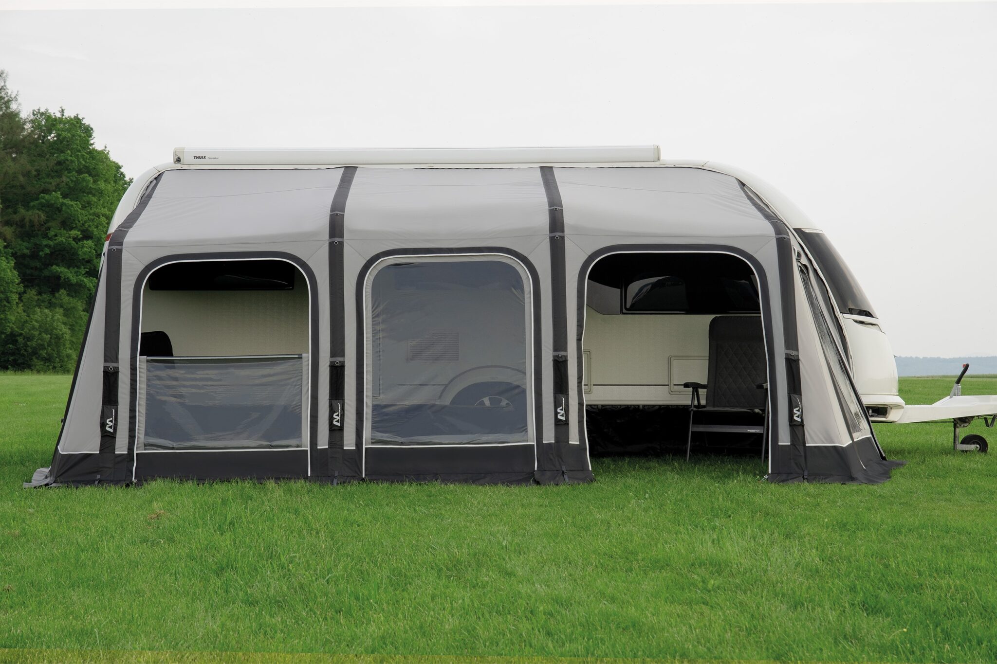 Vorzelt an Wohnwagen auf grüner Wiese