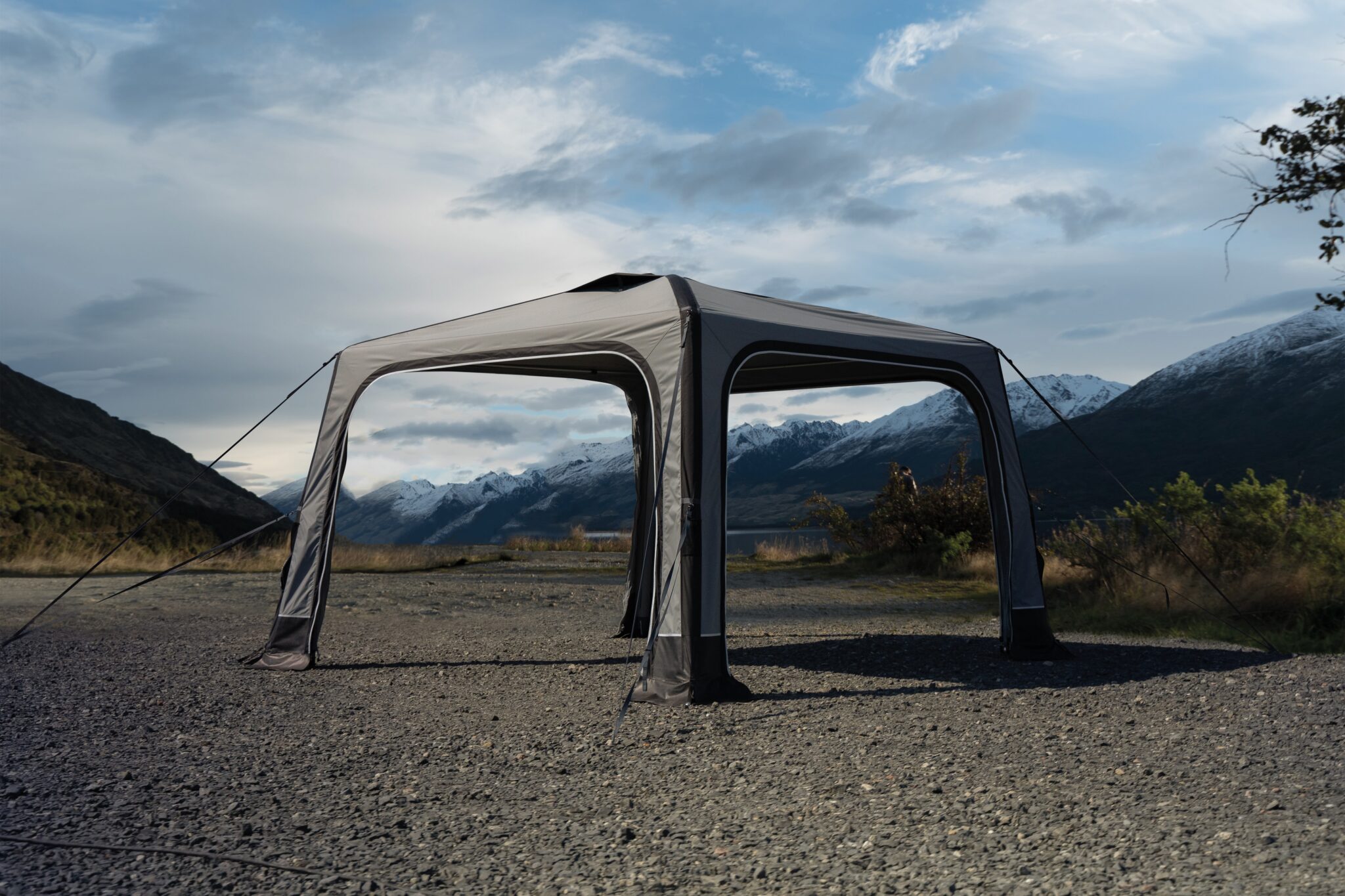 Pavillon auf kiesigem Boden vor Bergkulisse